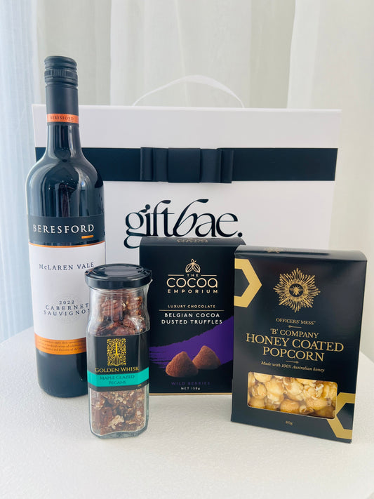 Gift basket with Beresford wine, truffles, honey coated popcorn, and other items on a white surface. | Luxury gift hampers Australia – beautifully curated gourmet hampers, wine gift boxes, and pamper hampers for all budgets. Perfect for birthdays, anniversaries, corporate gifts & special occasions. Gift Bae offers Perth same-day delivery & Australia-wide shipping. Shop the best gift hampers online today!