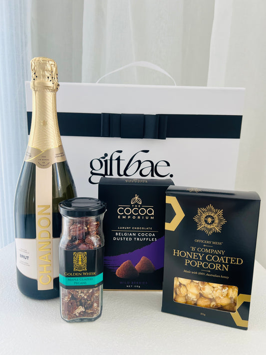 Gift box with Chandon champagne, truffles, and honey-coated popcorn on a white surface. | Luxury gift hampers Australia – beautifully curated gourmet hampers, wine gift boxes, and pamper hampers for all budgets. Perfect for birthdays, anniversaries, corporate gifts & special occasions. Gift Bae offers Perth same-day delivery & Australia-wide shipping. Shop the best gift hampers online today!